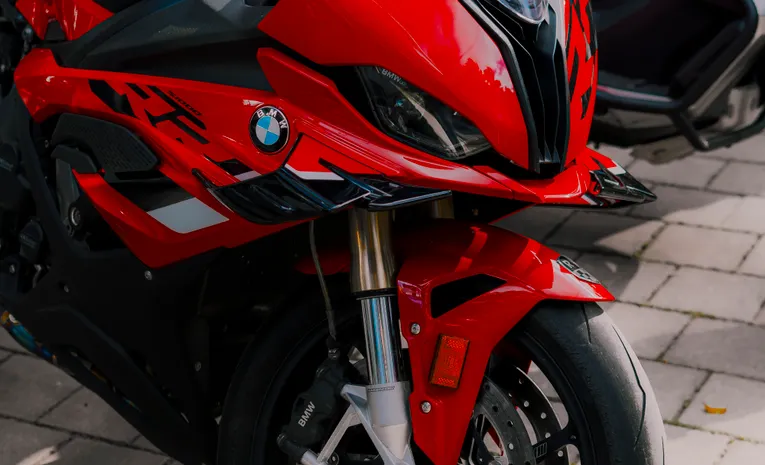 Sleek red BMW motorcycle parked outdoors showing mid-size bike