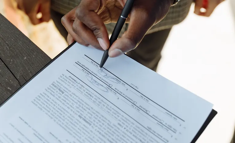 Person signing a car leasing or finance contract with a pen