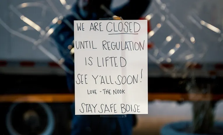 Closed sign displayed on a shop glass door