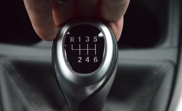 Close-up of a hand operating a manual car gear stick