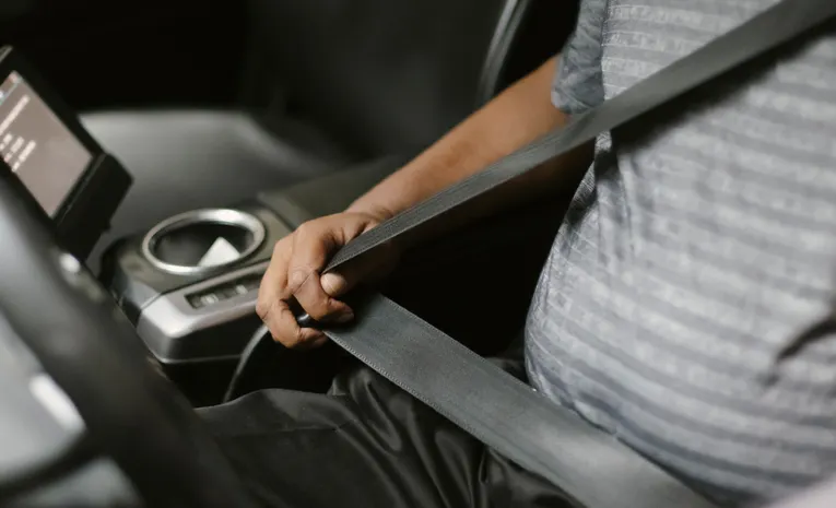 Man fastening seat belt in a car for safety before driving