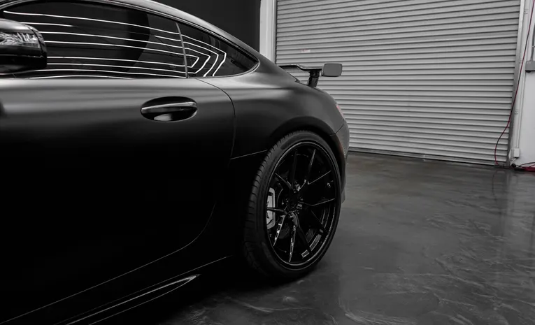 Matte black car finish parked in a modern garage