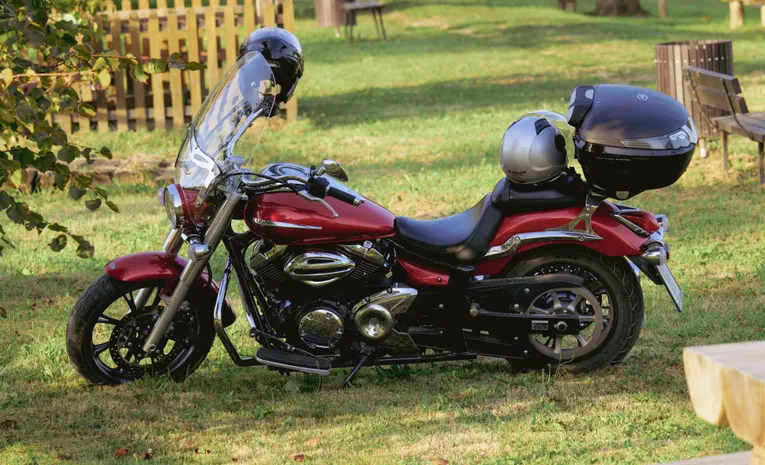 Motorbike parked outdoors with helmet on grass showing rider gear