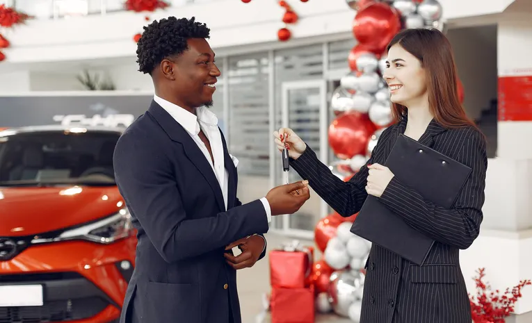 Car dealer handing over car keys during a trade-in transaction